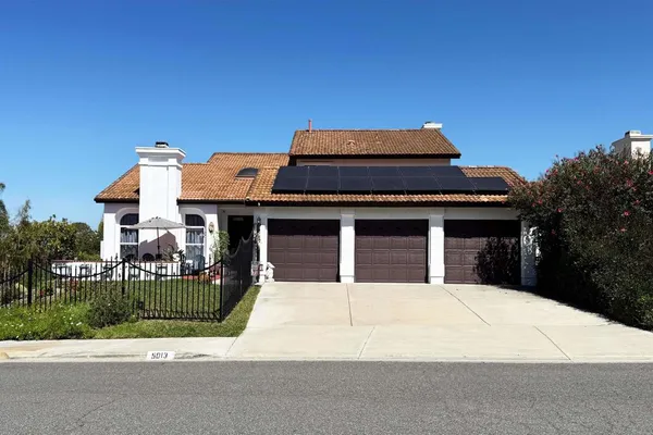 a view of a house with a small yard and potted plants