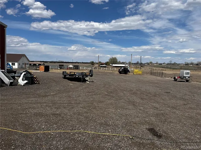 a backyard of a house with dining table and chairs