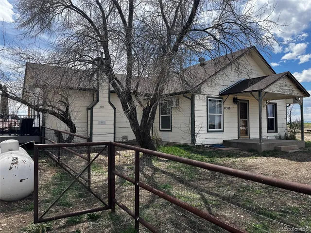 a view of a house with backyard and trees