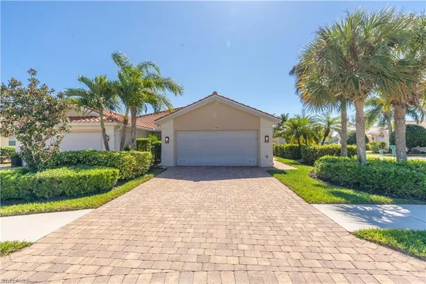 a front view of a house with a yard and palm trees