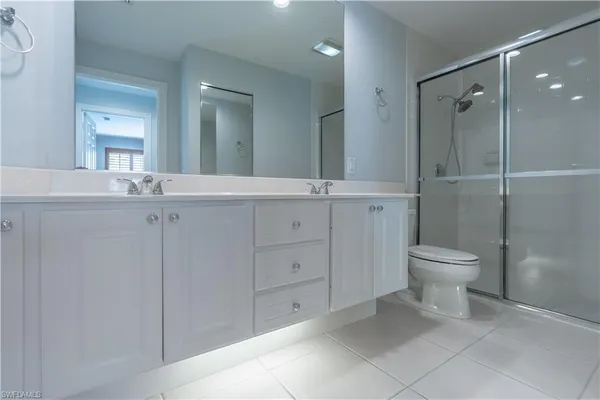 a bathroom with a granite countertop sink a toilet and a shower
