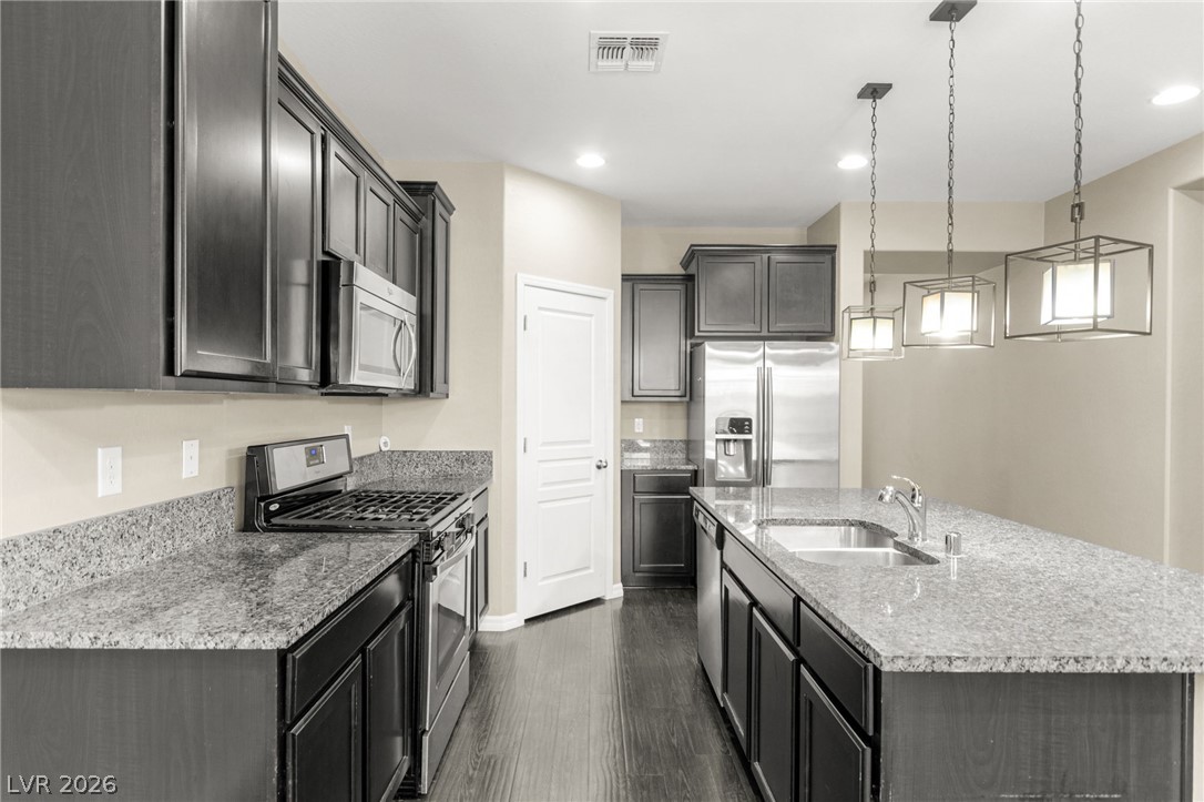 11048 Prairie Grove Road Las Vegas, NV 89179 - Photo 15 of 75 This kitchen showcases a modern aesthetic with ample counter space and well-lit design.