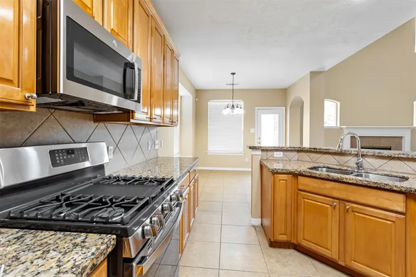 a kitchen with kitchen island granite countertop a sink stove and cabinets