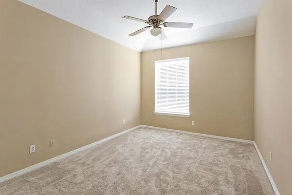 an empty room with windows and fan
