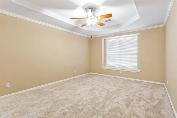 an empty room with windows and ceiling fan