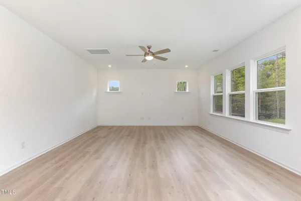 an empty room with a window and a ceiling fan