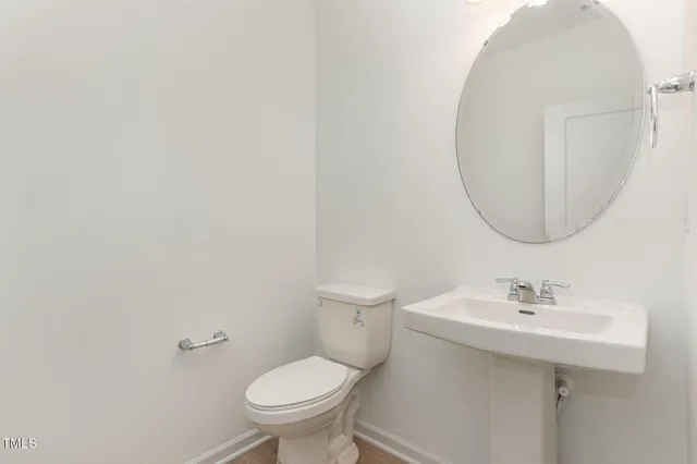 a bathroom with a sink toilet and a mirror