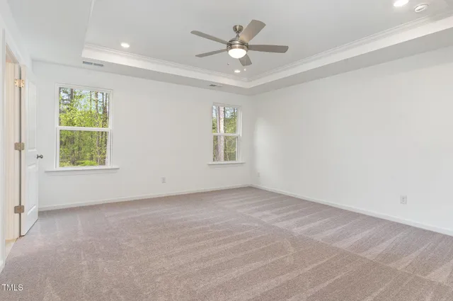 an empty room with windows and ceiling fan