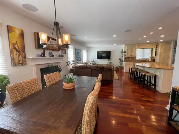 a view of a dining room and livingroom with furniture wooden floor a chandelier
