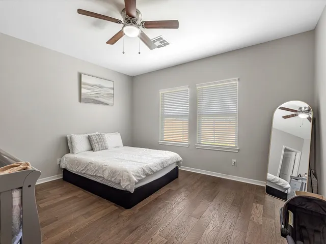 a bedroom with a bed wooden floor and window