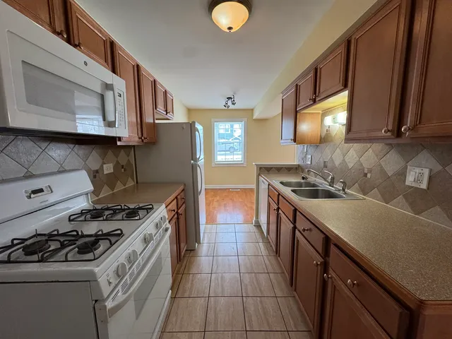 a kitchen with stainless steel appliances granite countertop a stove a sink and a microwave