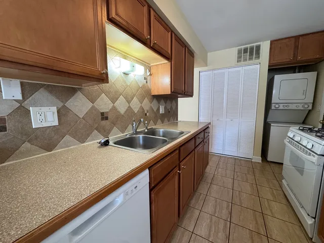 a kitchen with stainless steel appliances granite countertop a sink and a refrigerator