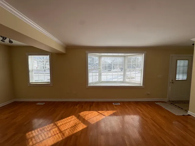 a view of a room with wooden floor and a window