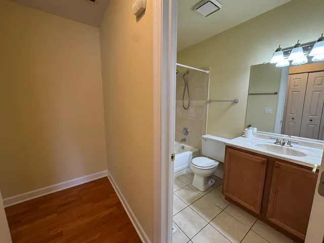 a bathroom with a granite countertop toilet a sink and a mirror
