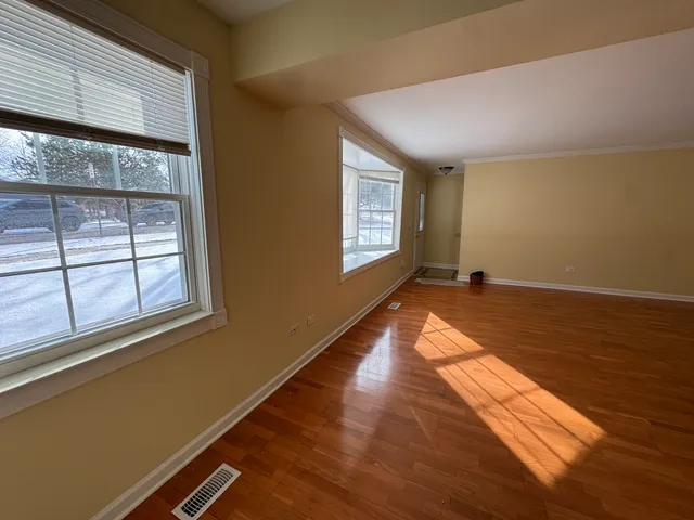 a view of a room with wooden floor and windows