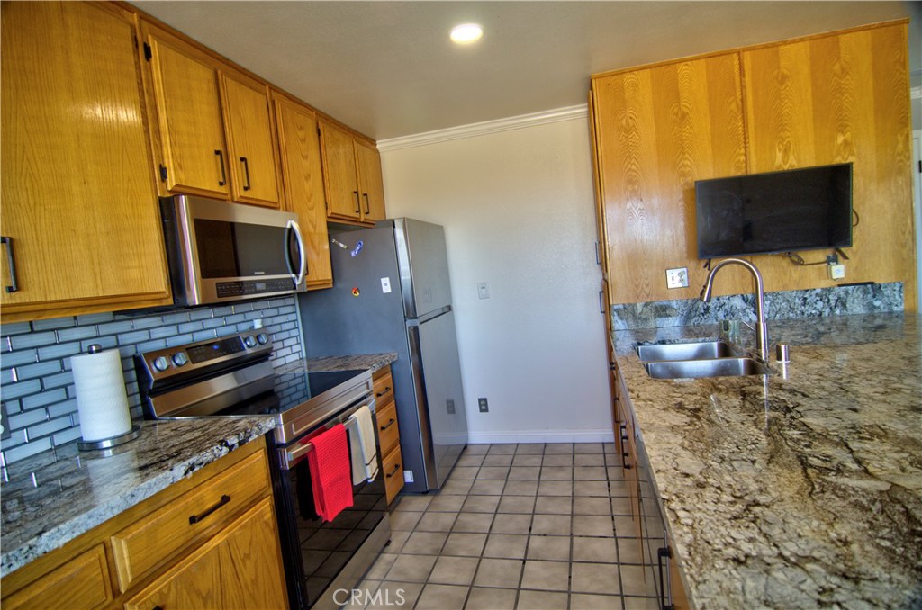 51063 Joshua Tree Road Landers, CA 92285 - Photo 20 of 38 The kitchen got a major face lift a few years ago. All new stainless matching appliances, a tile backsplash, and really nice granite counter tops
