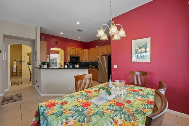 a bedroom with a bed dresser and a chandelier