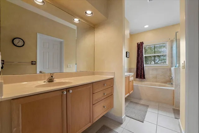 a bathroom with a granite countertop sink a mirror and a bathtub