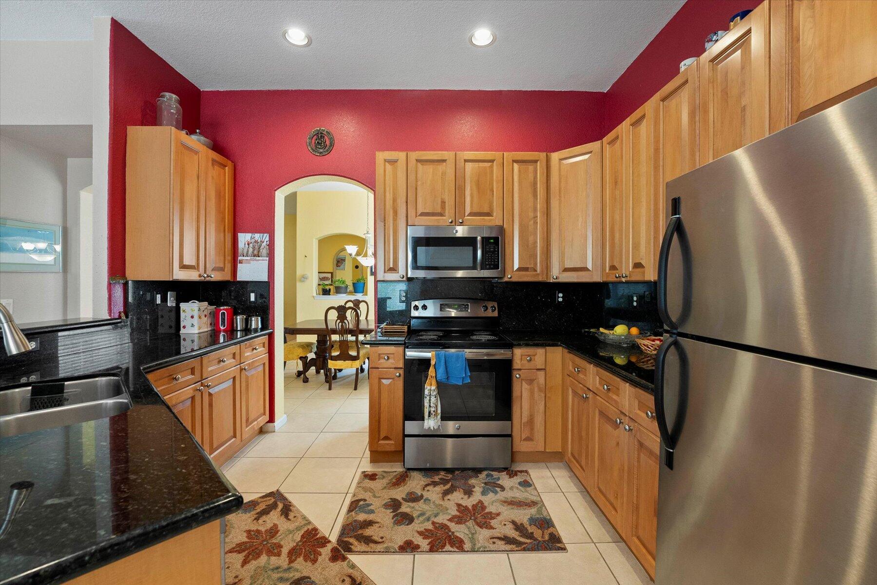 5002 Victoria Circle West Palm Beach, FL 33409 - Photo 9 of 37 a kitchen with stainless steel appliances granite countertop a refrigerator a stove top oven a sink and dishwasher