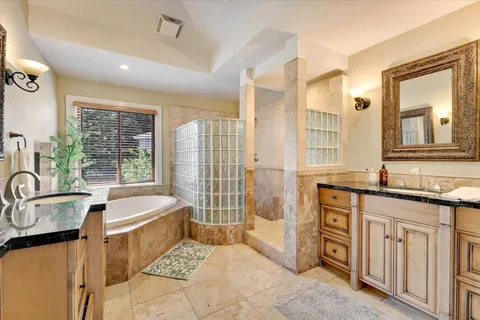 a spacious bathroom with a tub sink and mirror