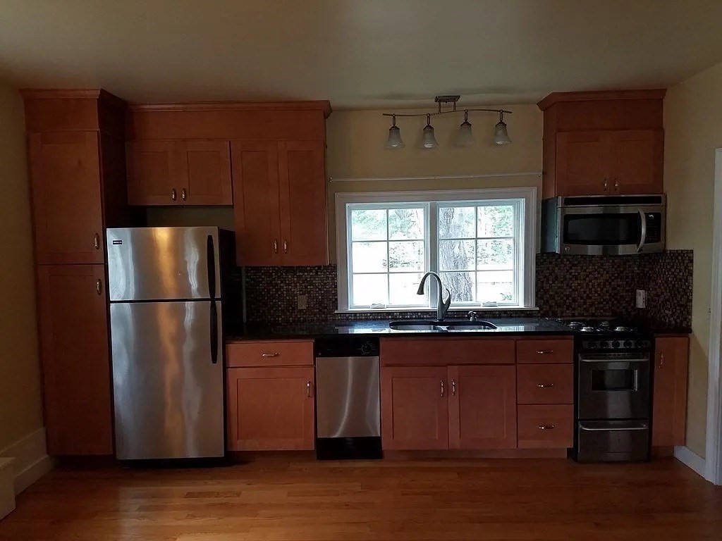161 Chestnut Street Amherst, MA 01002 - Photo 26 of 41 a kitchen with granite countertop a refrigerator a sink and wooden floors