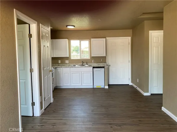 a view of kitchen with wooden floor electronic appliances and window