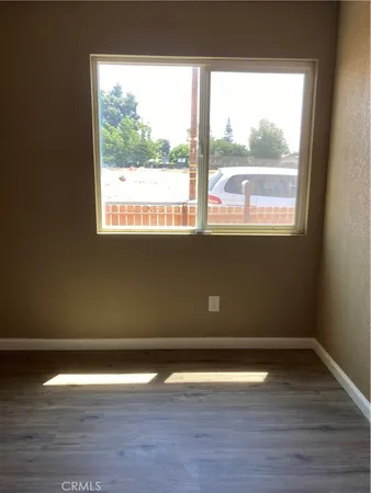 a view of a room with wooden floor and a window