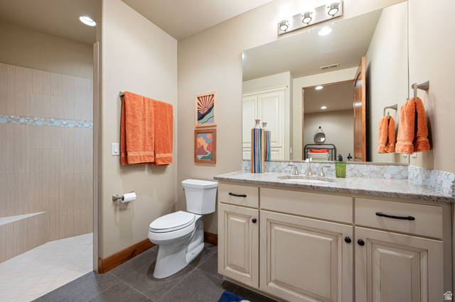 2331 West Entrada Trail, Unit 61 St. George, UT 84770 - Photo 47 of 69 Bathroom featuring a shower with tiled walls and an integrated bench, dark tile flooring, and a white toilet