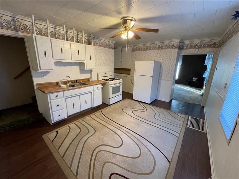 211 South Walnut Street New Castle, PA 16101 - Photo 4 of 18 a kitchen with stainless steel appliances granite countertop a stove a refrigerator a sink a stove and a dining table with wooden floor