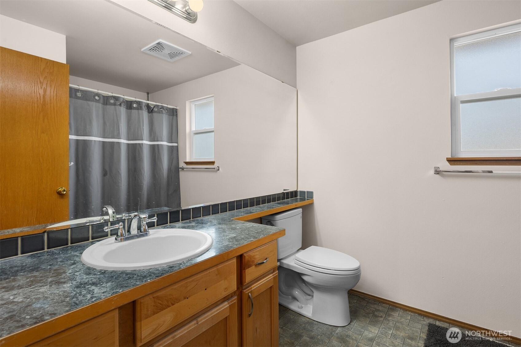 2632 Northeast 24th Court Renton, WA 98056 - Photo 16 of 33 a bathroom with a granite countertop sink a toilet and a mirror