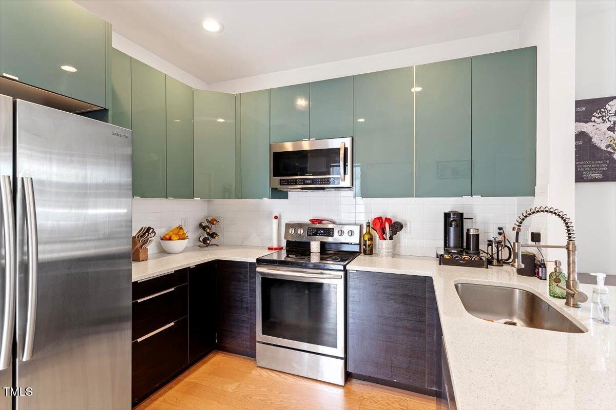 1314 South East Street Raleigh, NC 27601 - Photo 19 of 39 a kitchen with stainless steel appliances granite countertop a sink stove and refrigerator