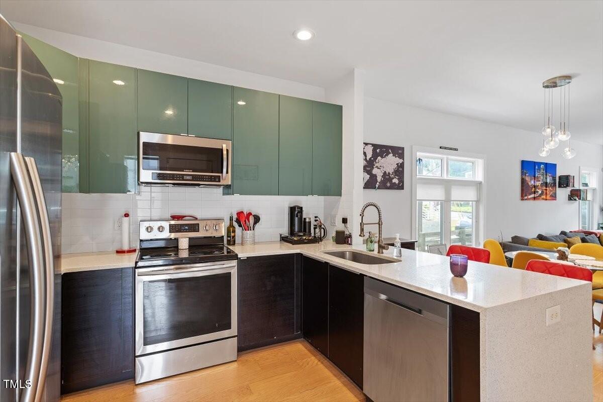 1314 South East Street Raleigh, NC 27601 - Photo 20 of 39 a kitchen with stainless steel appliances a sink dishwasher a refrigerator and a stove with wooden floor