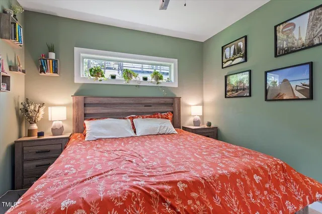 a bedroom with a bed and painting on the wall