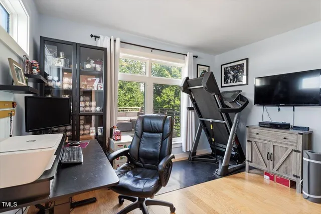 a work room with furniture a flat screen tv and a floor to ceiling window