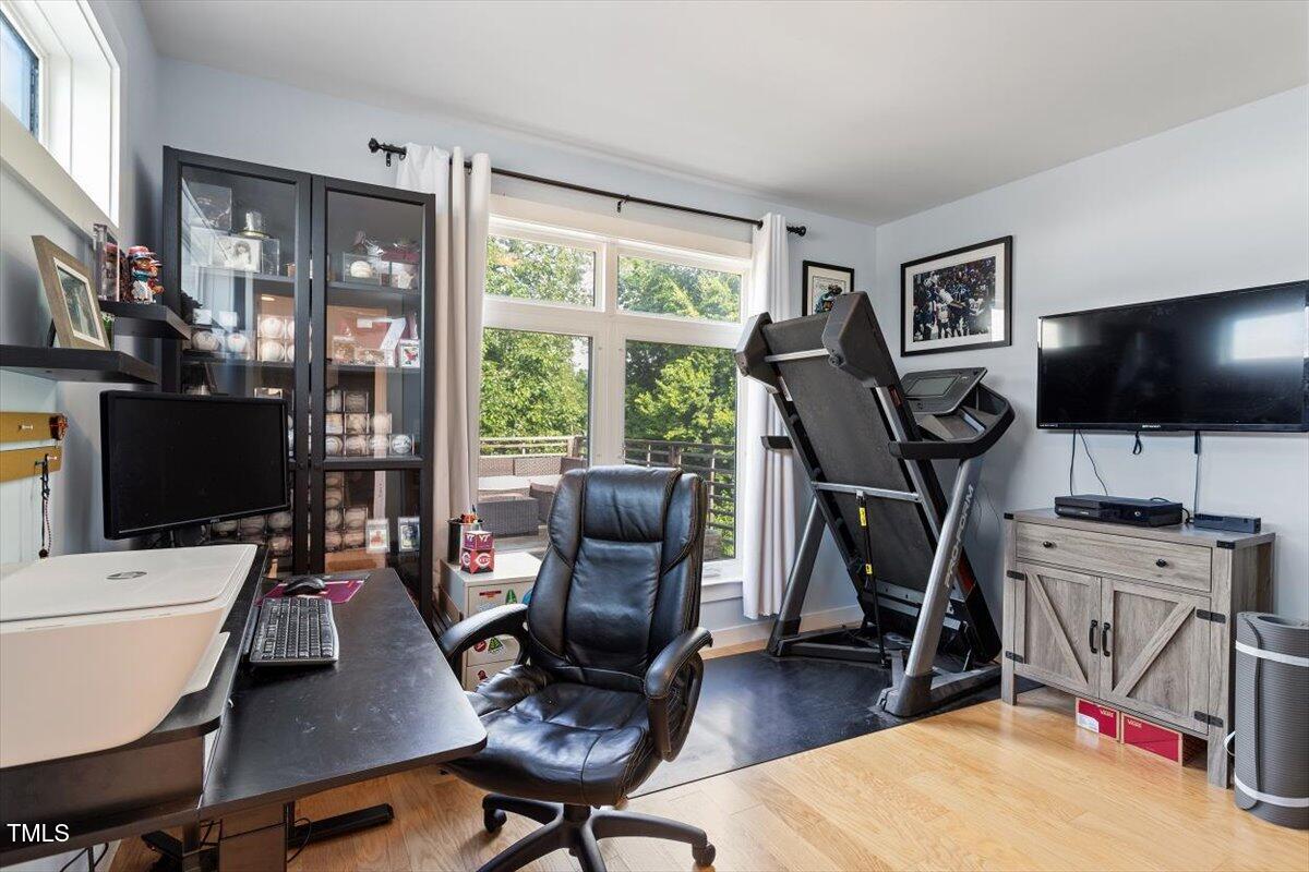 1314 South East Street Raleigh, NC 27601 - Photo 34 of 39 a work room with furniture a flat screen tv and a floor to ceiling window
