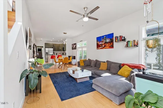 a living room with furniture kitchen view and a window