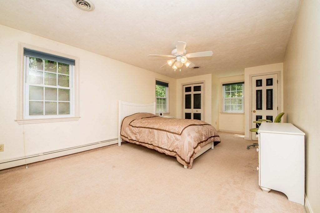 5 Chief Lane Canton, MA 02021 - Photo 35 of 42 a spacious bedroom with a large bed and a chandelier