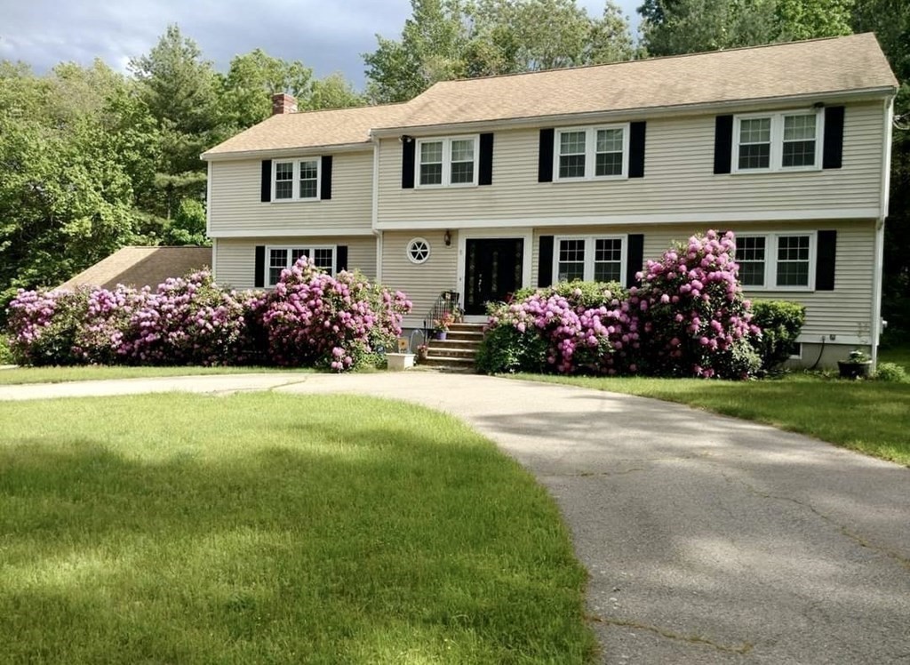 5 Chief Lane Canton, MA 02021 - Photo 7 of 42 a front view of a house with a yard and a garden