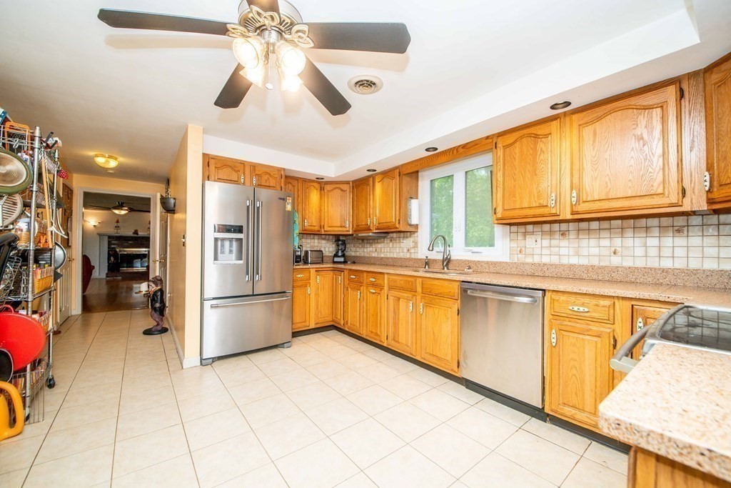 5 Chief Lane Canton, MA 02021 - Photo 8 of 42 a kitchen with a refrigerator a sink dishwasher with a stove and cabinets