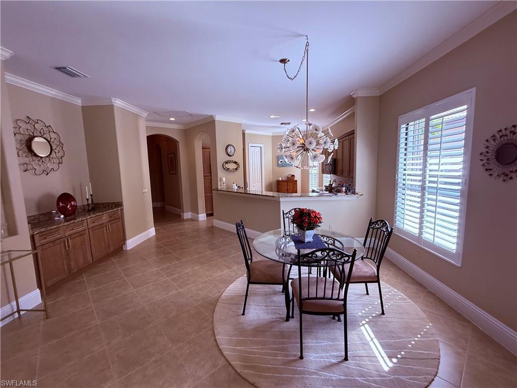 7543 Moorgate Point Way Naples, FL 34113 - Photo 12 of 31 a view of a dining room with furniture window and wooden floor