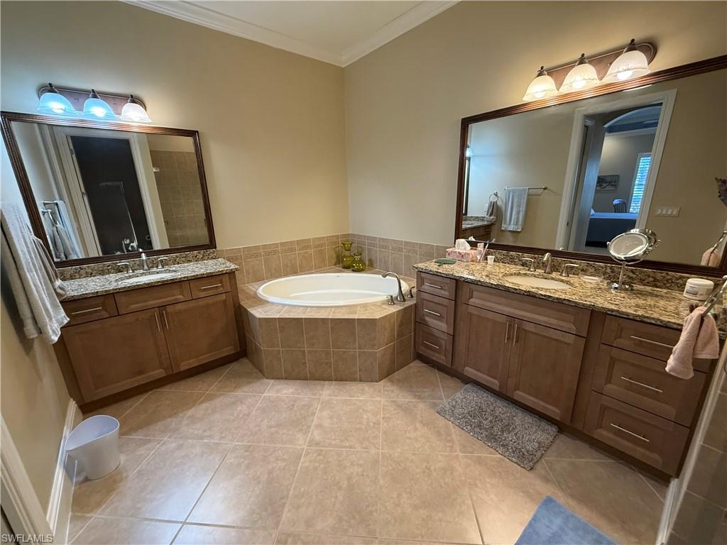 7543 Moorgate Point Way Naples, FL 34113 - Photo 23 of 31 a bathroom with a tub sink and mirror