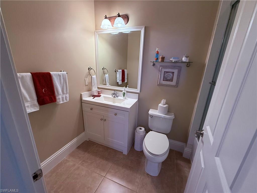 7543 Moorgate Point Way Naples, FL 34113 - Photo 30 of 31 a bathroom with a toilet sink and mirror