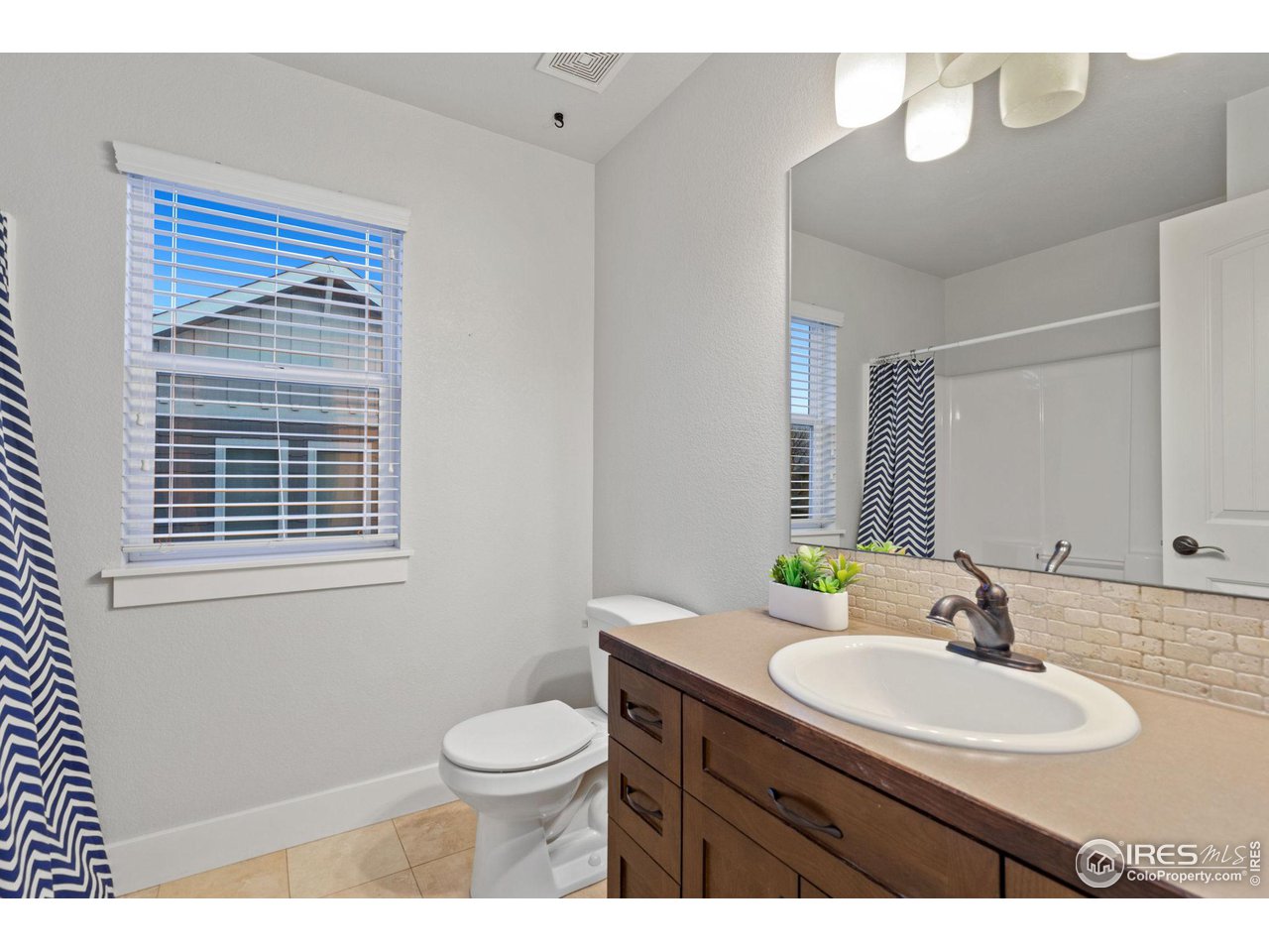 2263 Bellwether Lane Fort Collins, CO 80521 - Photo 24 of 40 a bathroom with a sink a toilet and a mirror