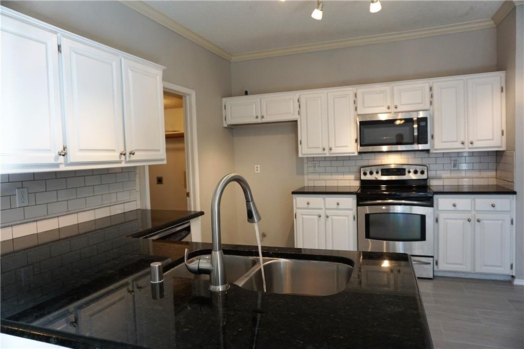 a kitchen with a sink cabinets and appliances