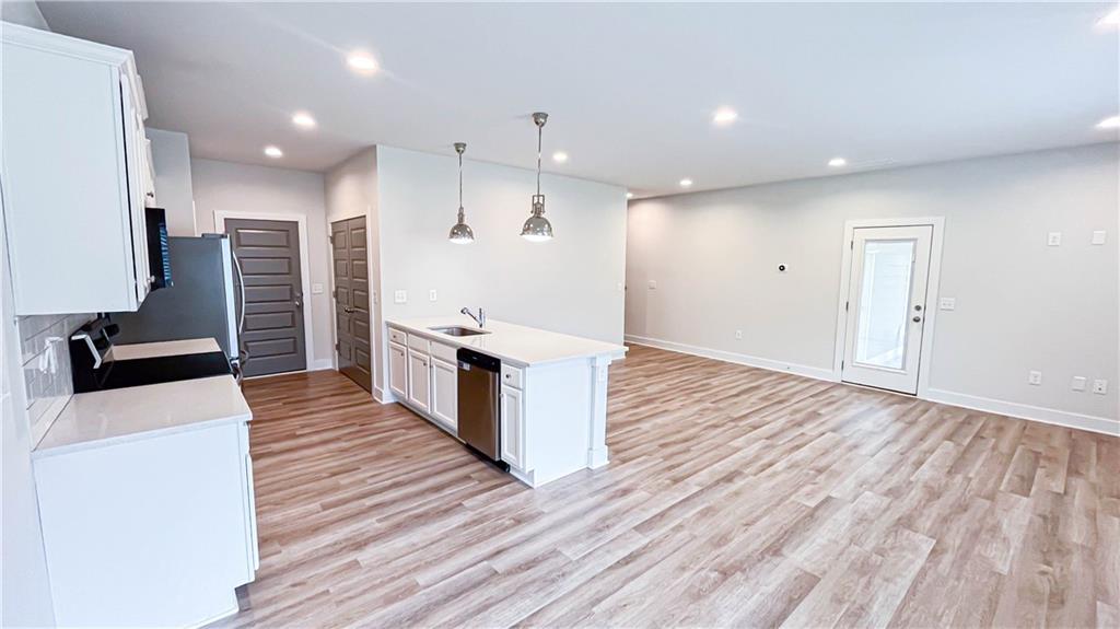 740 Eudora Welty Way Athens, GA 30607 - Photo 10 of 57 a large kitchen with stainless steel appliances a large center island wooden floor and living room view