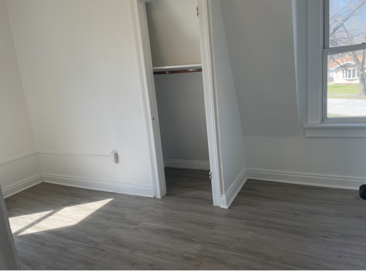 17104 Wentworth Avenue, Unit 6 Lansing, IL 60438 - Photo 5 of 8 an empty room with wooden floor and windows