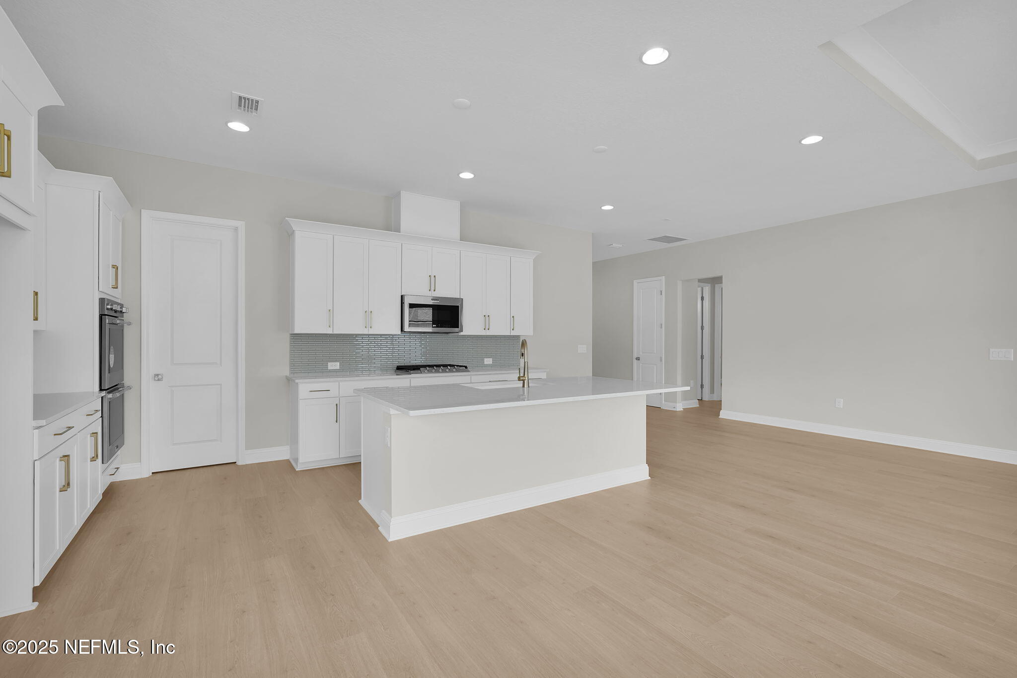 440 Slash Pine Place Yulee, FL 32097 - Photo 17 of 38 a large white kitchen with white cabinets and stainless steel appliances