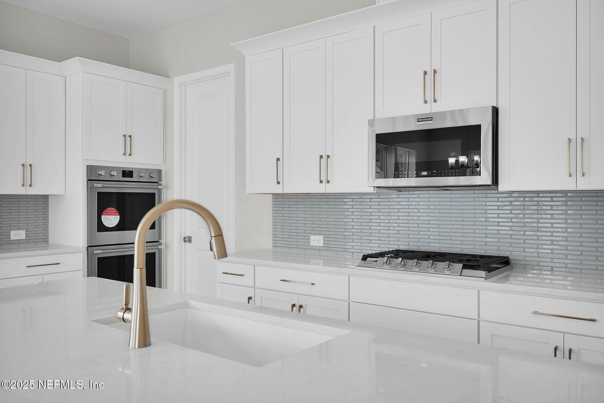 440 Slash Pine Place Yulee, FL 32097 - Photo 18 of 38 a kitchen with white cabinets and appliances