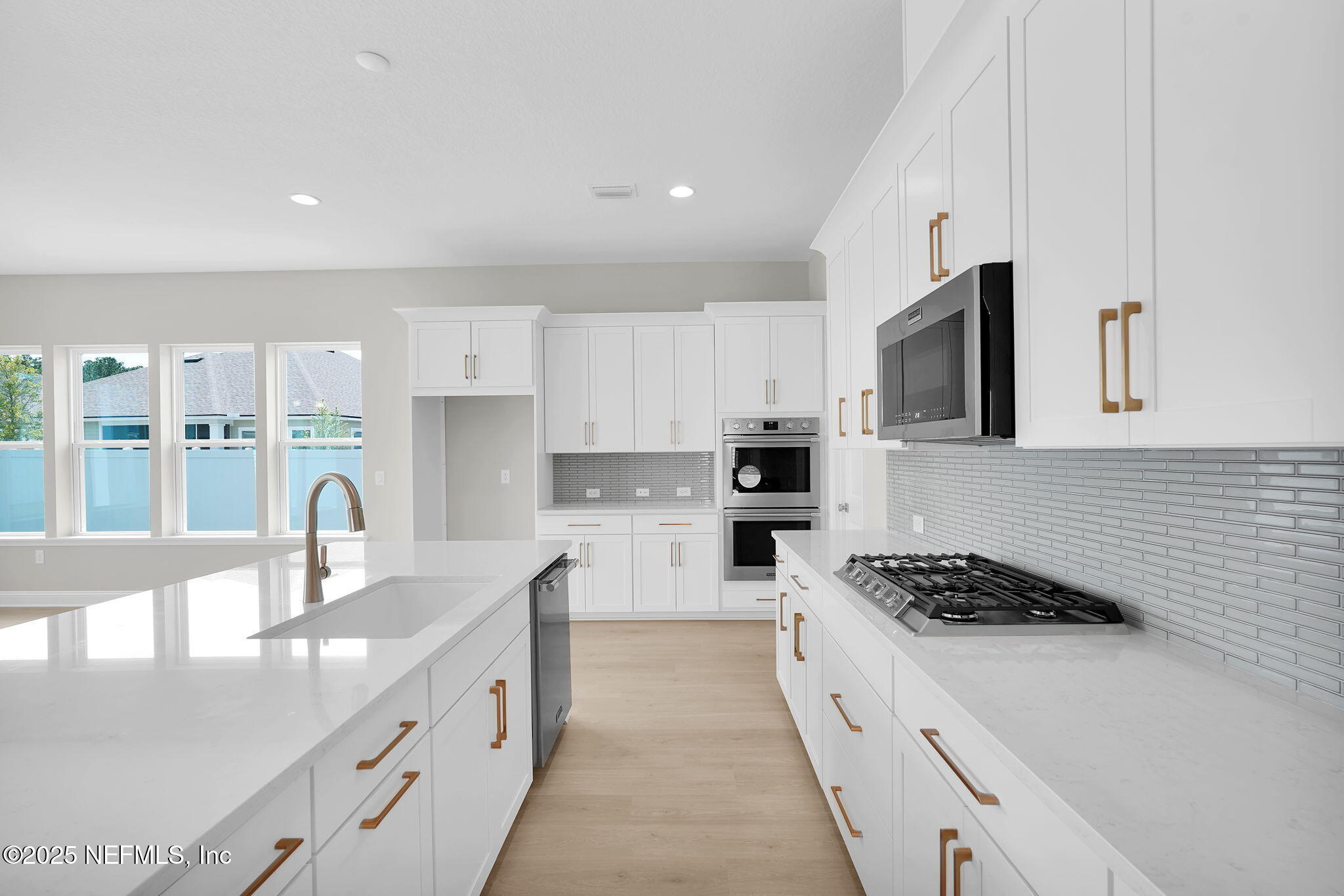 440 Slash Pine Place Yulee, FL 32097 - Photo 19 of 38 a kitchen with stainless steel appliances kitchen island granite countertop a stove a sink a microwave and a refrigerator