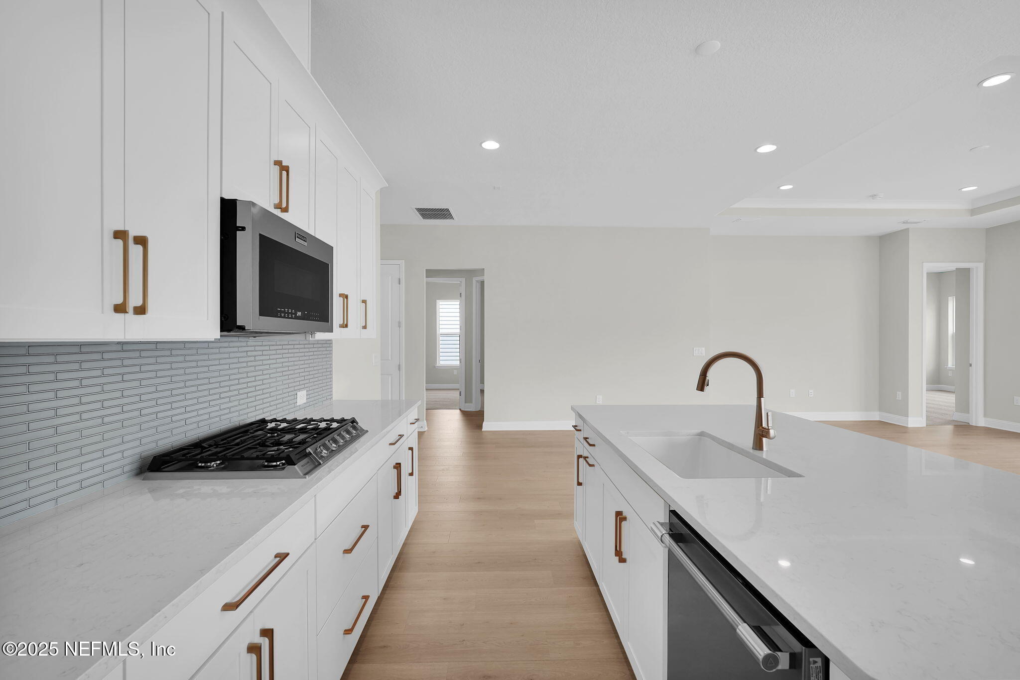 440 Slash Pine Place Yulee, FL 32097 - Photo 21 of 38 a kitchen with stainless steel appliances a sink a stove top oven a counter space and cabinets